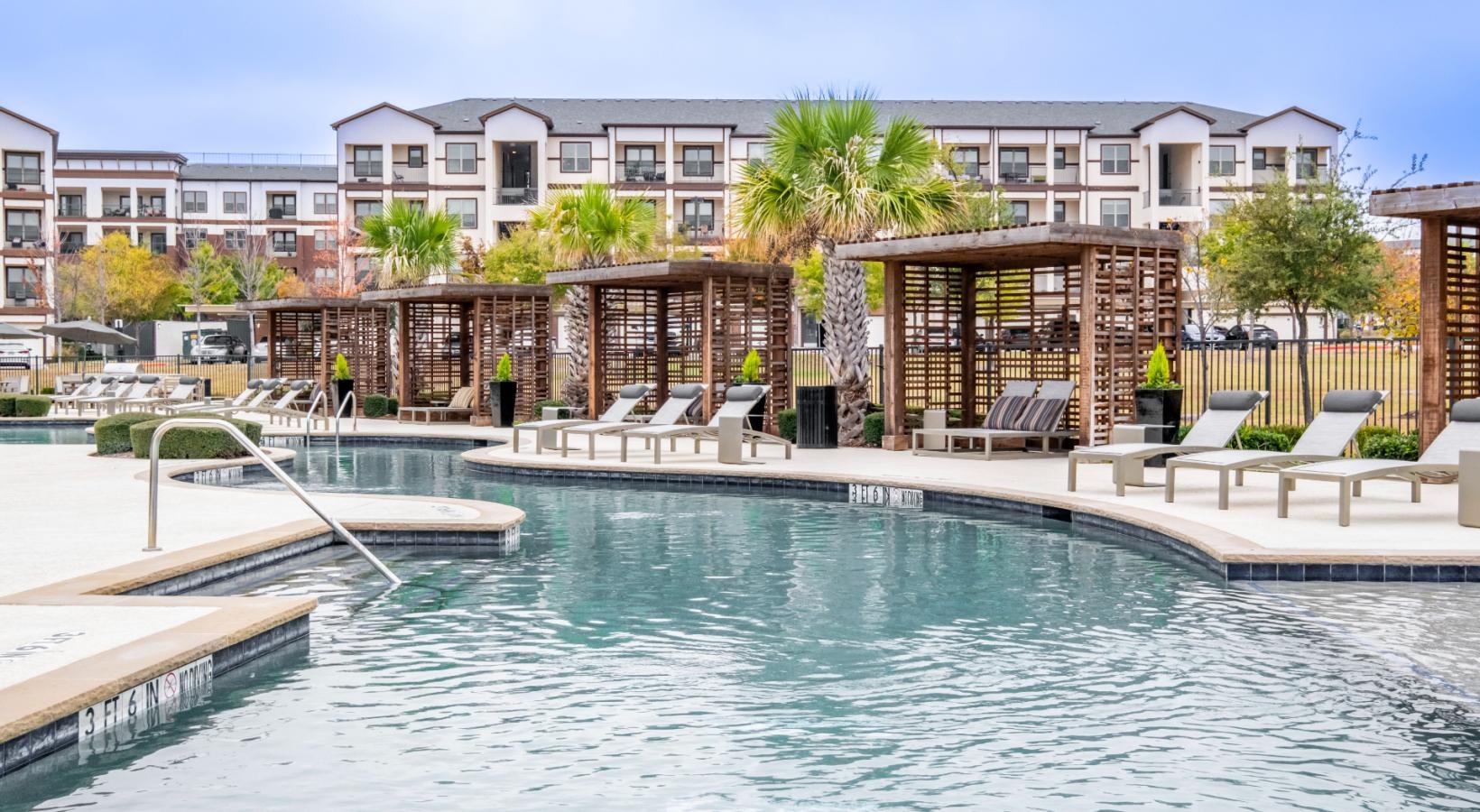 Resort-style swimming pool a pool with a building in the background