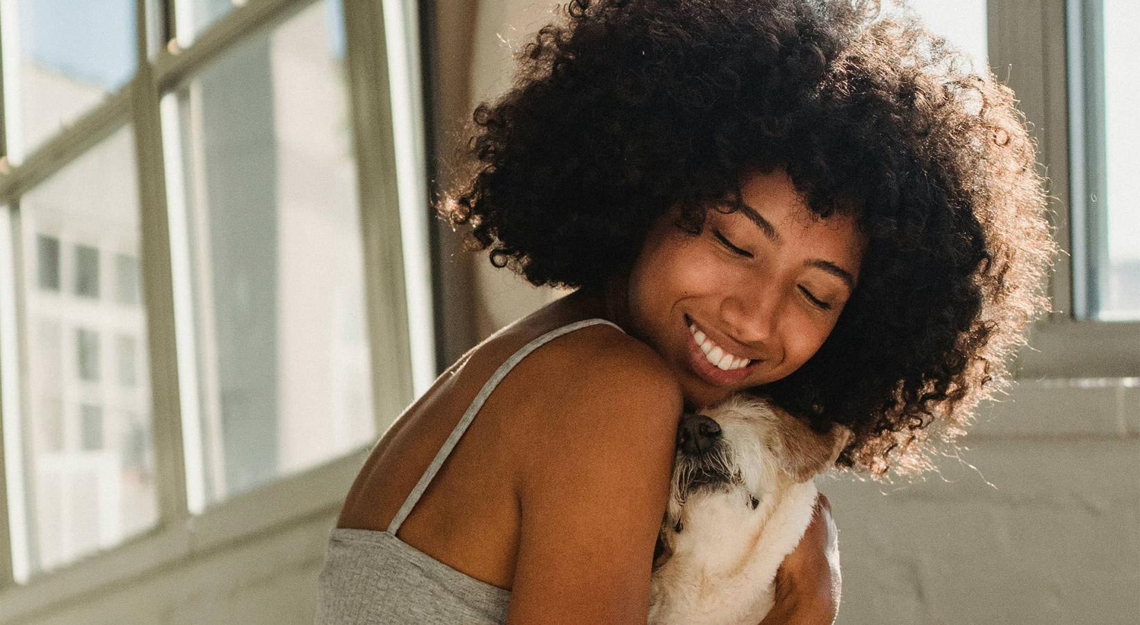 We're a pet friendly community a girl on a bed hugging her dog